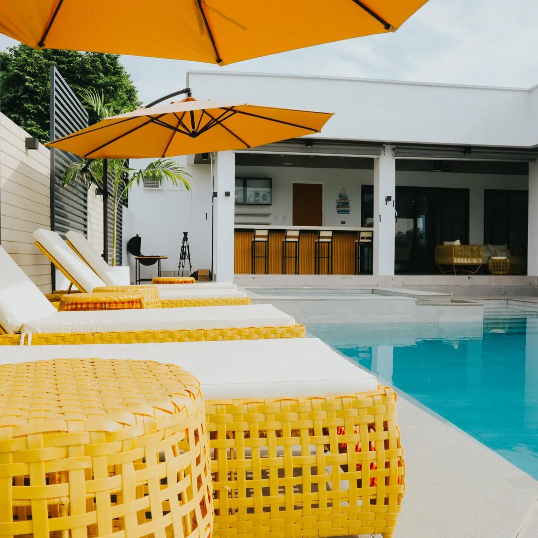 Poolside with yellow wicker loungers and umbrella